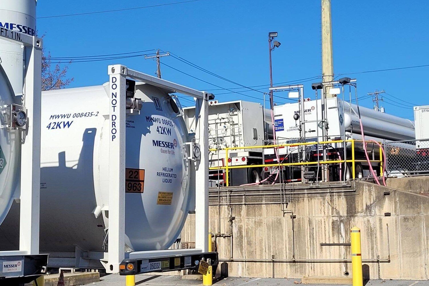 Helium Refrigerated Liquid,” with visible safety signage and connection hoses under a clear blue sky